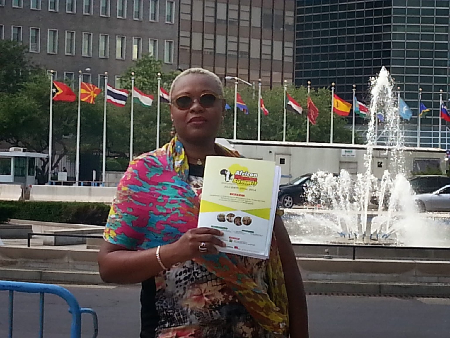 Event crew member holding the African Women Summit program near the United Nations complex in New York