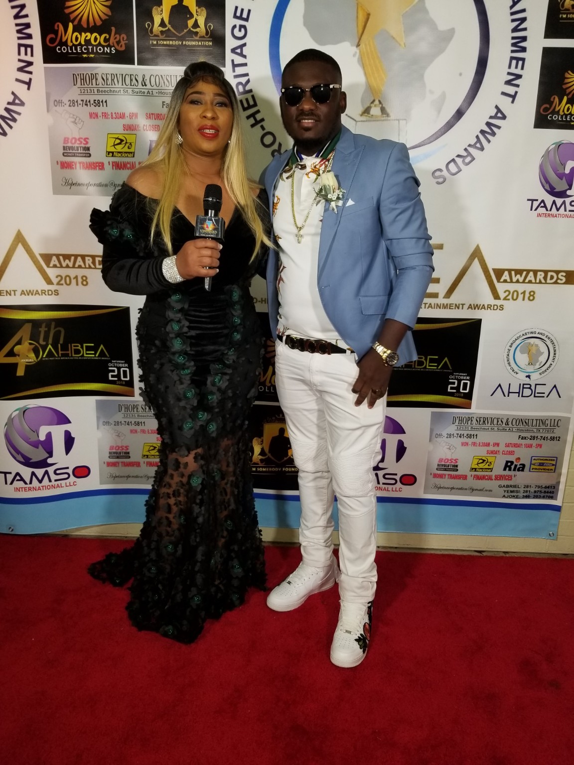 Dr. Ranti holding a microphone with an awards guest at the Houston red-carpet event